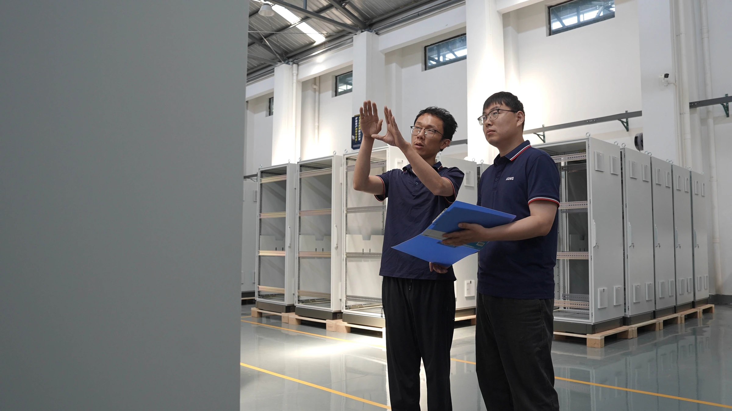 Engineers reviewing cabinet build documentation on the shop floor